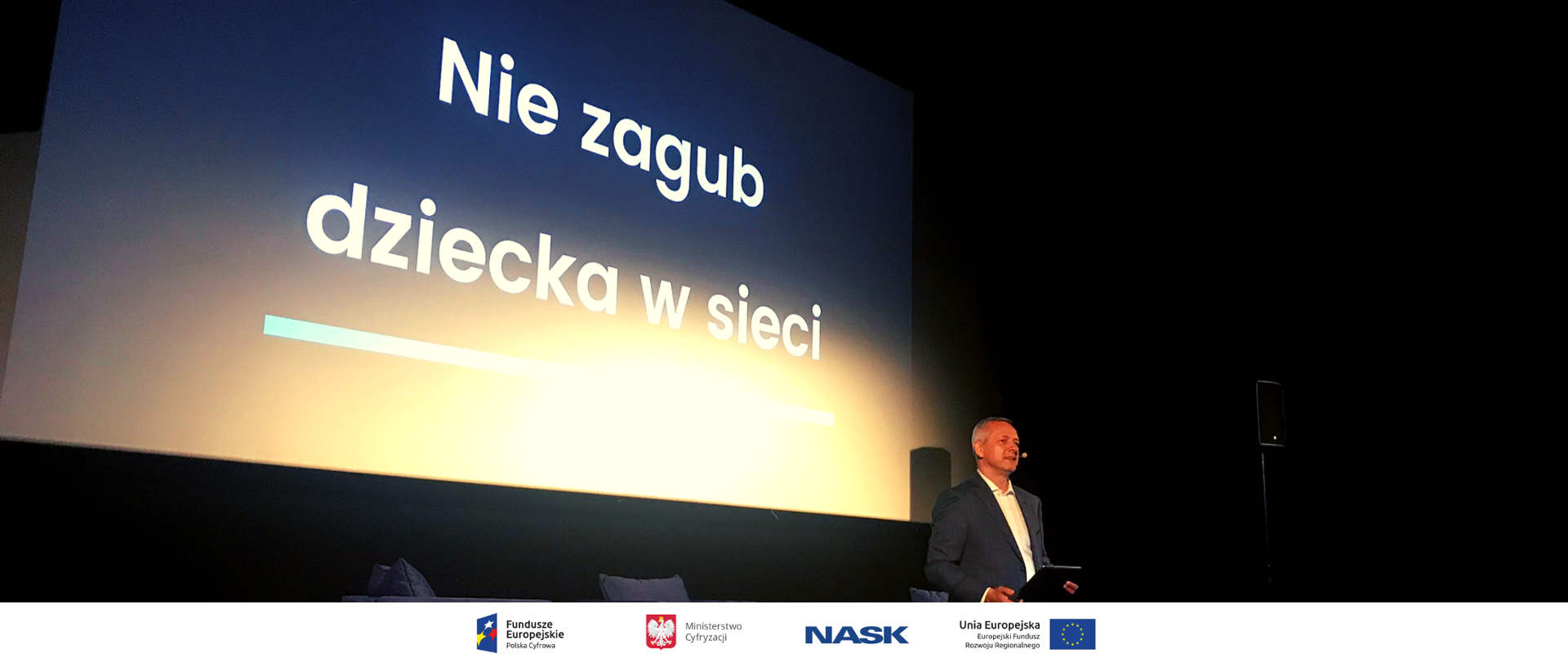 Minister Marek Zagórski podczas konferencji, w tle ekran z napisem "nie zagub dziecka w sieci"