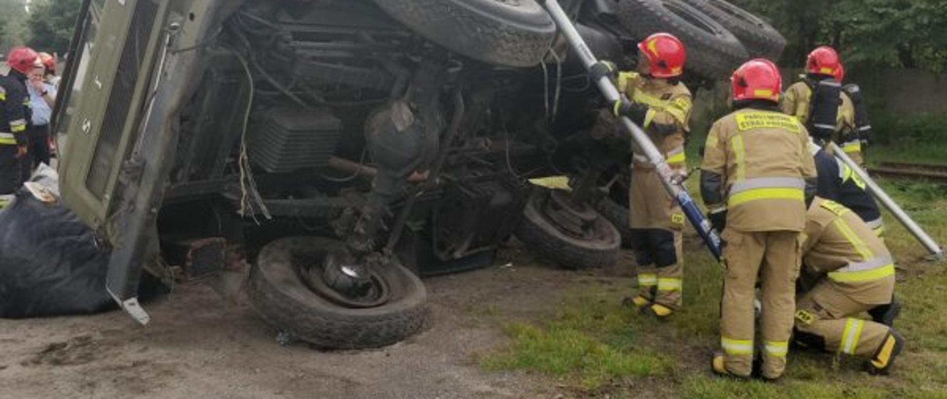 Ćwiczenia Szkolnej Jednostki Ratowniczo-Gaśniczej Centralnej Szkoły PSP w Częstochowie - strażacy podczas stabilizacji podwozia samochodu ciężarowego. Od strony podwozia podpory, a od strony nadwozia poduszka pneumatyczna.