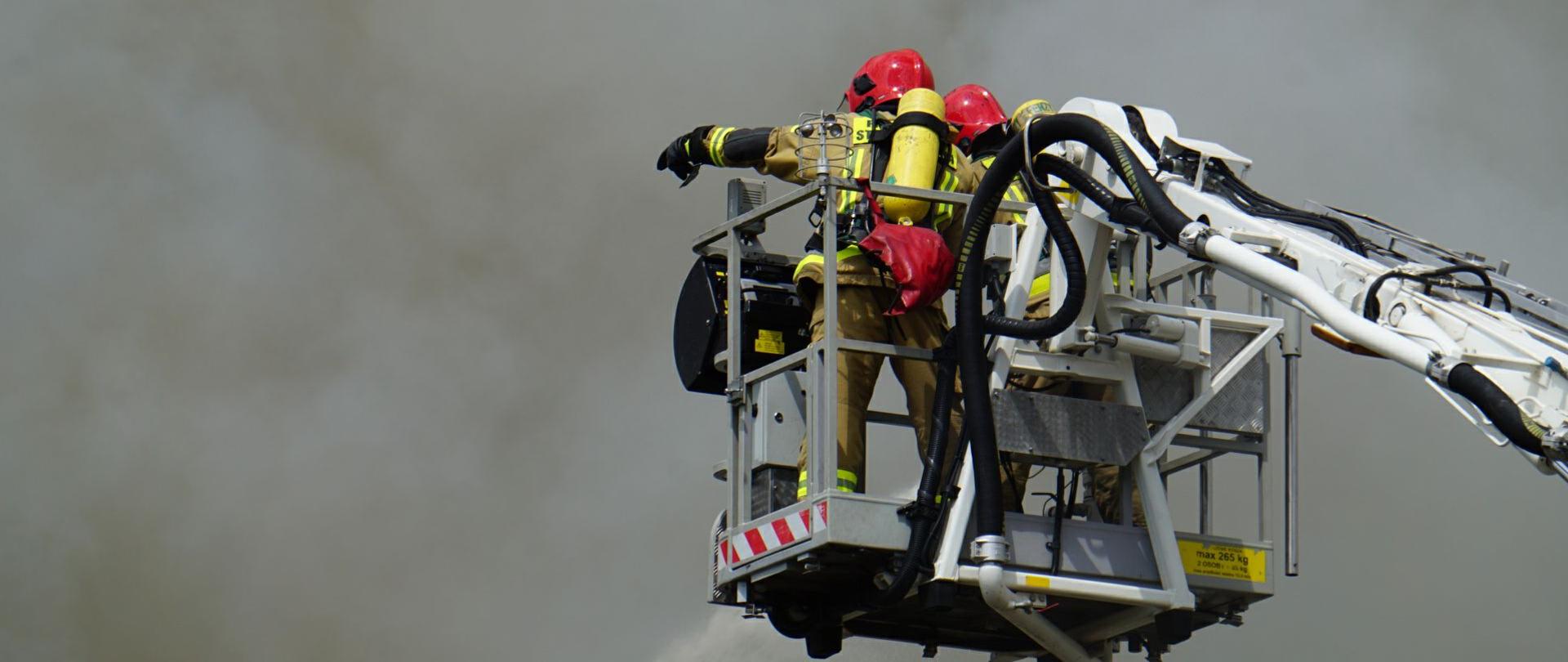 Strażacy gaszą pożar z podnośnika