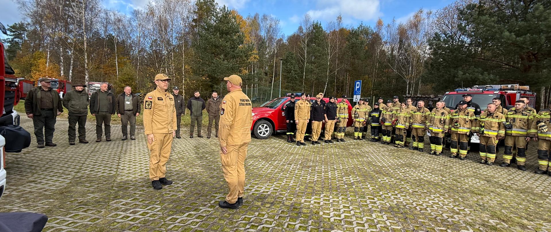 Uczestnicy ćwiczeń w szyku. Dowódca składa meldunek komendantowi. 