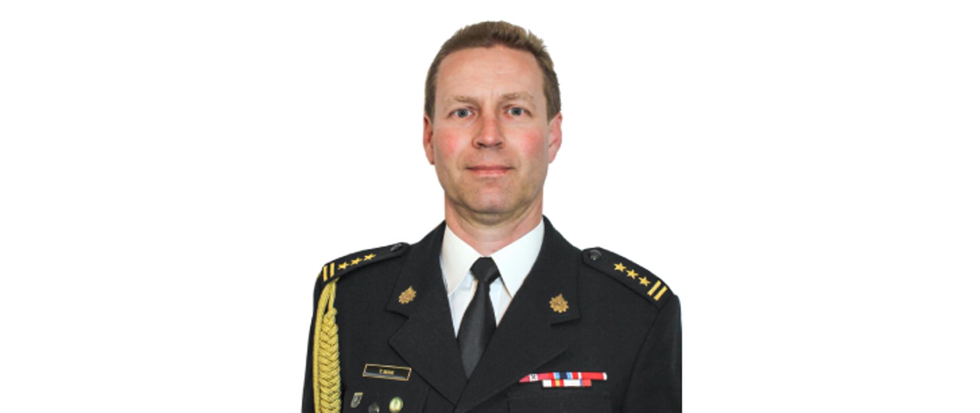 Komendant powiatowy starszy brygadier Tomasz Mak w mundurze galowym.