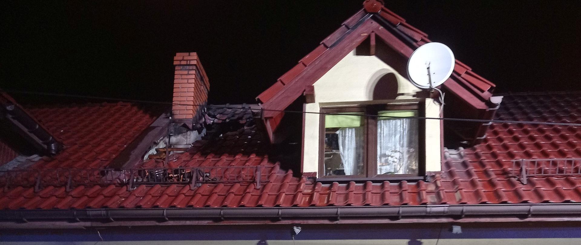 Dom mieszkalny jednorodzinny z częściowo nadpalonym dachem. Zdjęcie od frontu budynku.