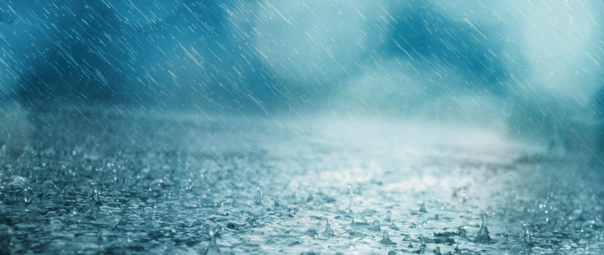Zdjęcie przedstawia ulewny deszcz padający na jezdnię.