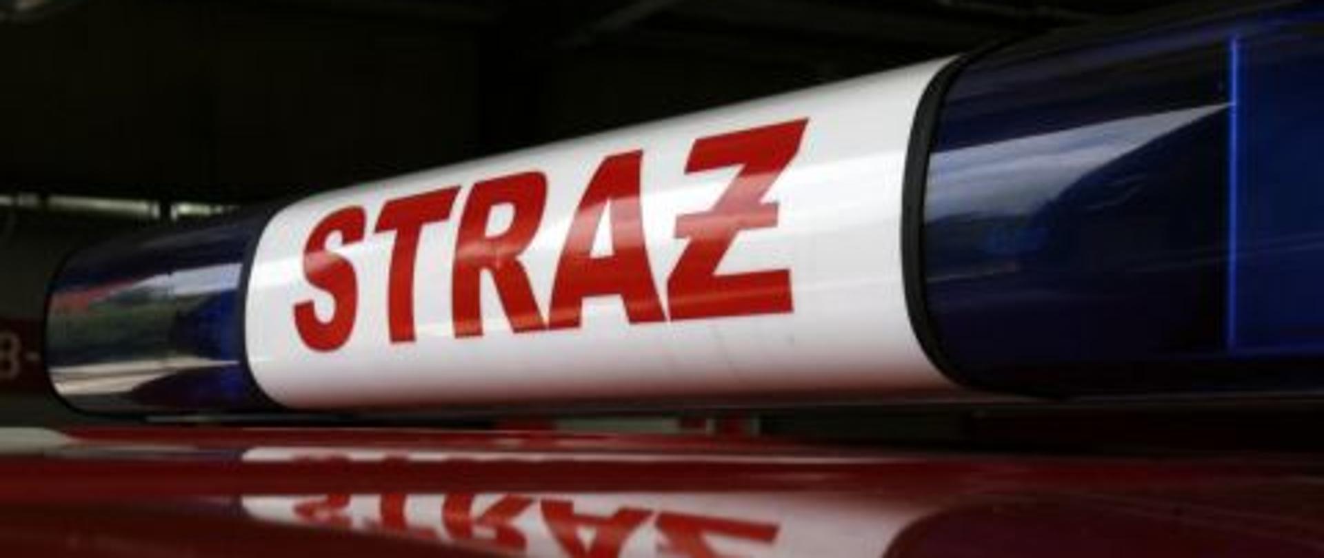 Sygnały świetlne z napisem straż na dachu samochodu pożarniczego