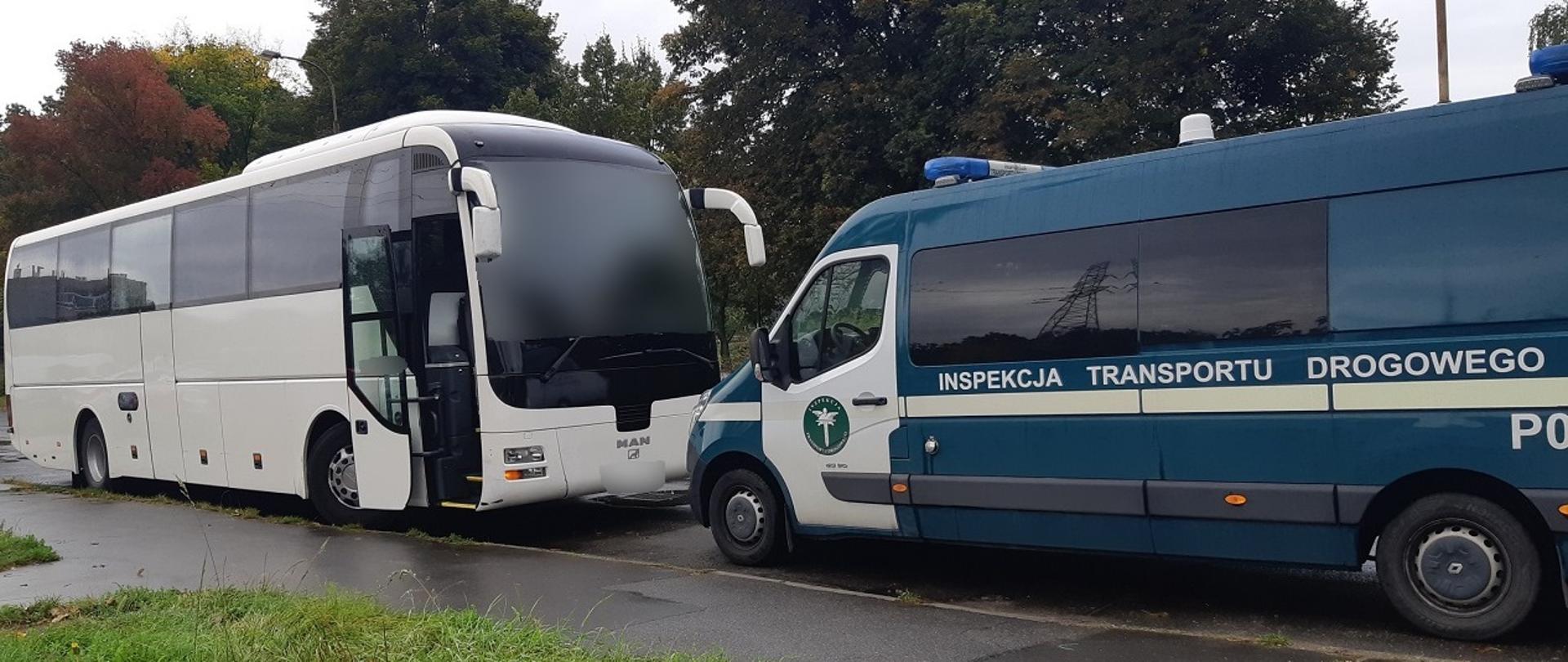 Biały autobus z otwartymi drzwiami stoi naprzeciwko zielonego radiowozu typu bus.