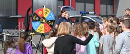 Dzieci zwiedzają stanowisko edukacyjne przygotowane przez straż miejską