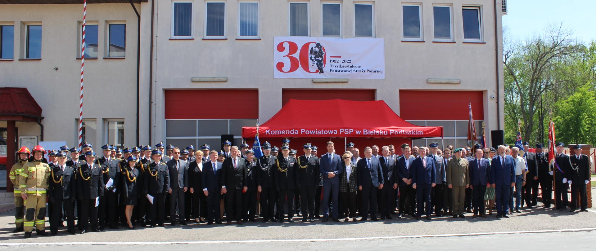 Zdjęcie grupowe z Powiatowych obchodów Dnia Strażaka z logo Trzydziestolecia Państwowej Straży Pożarnej 