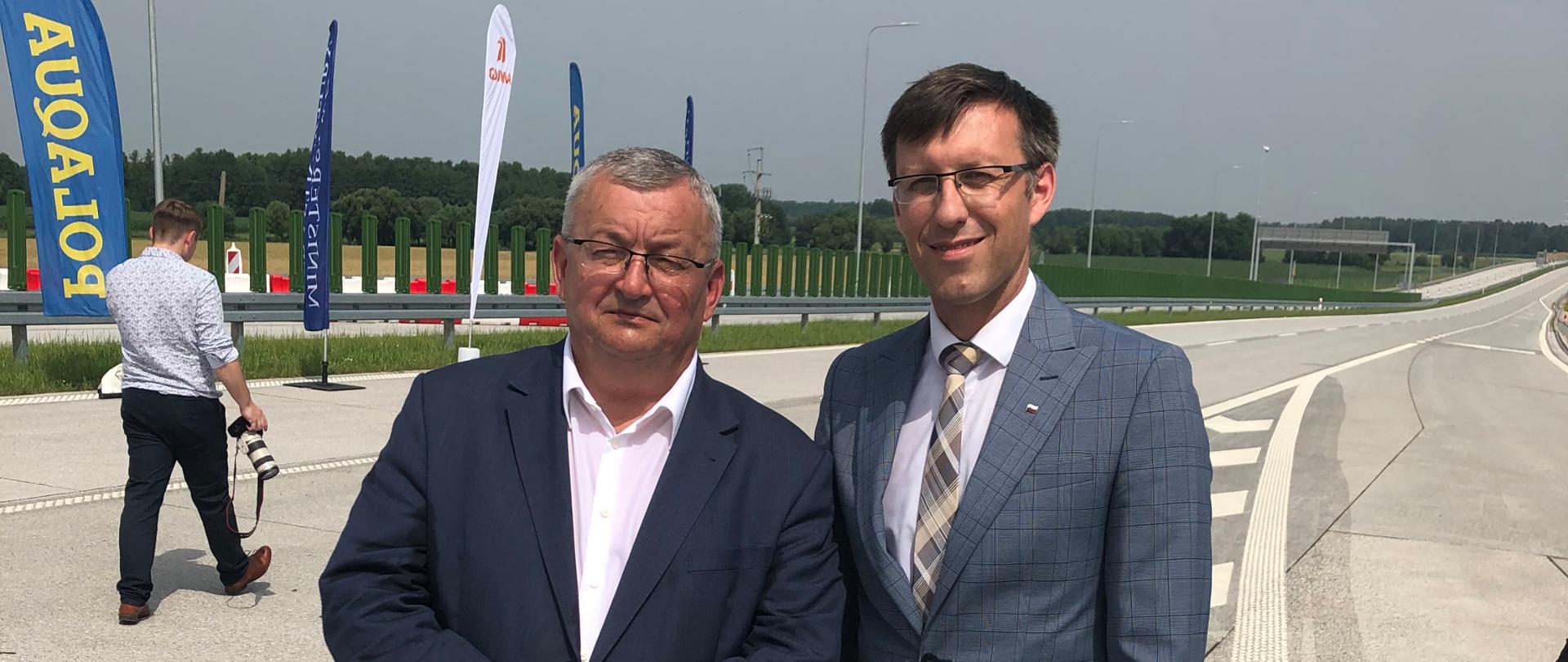 Na zdjęciu znajduje się dwóch mężczyzn, którzy stoją na drodze