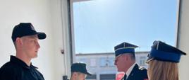 Zdjęcie przedstawia przedstawia nowo przyjętych do służby strażaków podczas uroczystego wręczania aktów mianowania.