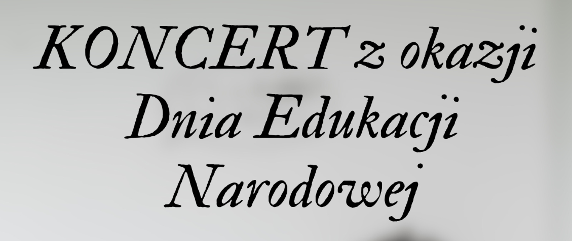 Plakat z rozmytym zdjeciem sali lekcyjnej w jasnych odcieniach. Na środku plakatu lawka lekcyjna a przy niej uczeń i obok stojąca nauczycielka tlumacząca coś uczniowi.
Na górze plakatu informacja o nazwie koncertu a na dole szczegóły na temat daty i miejsca koncertu.