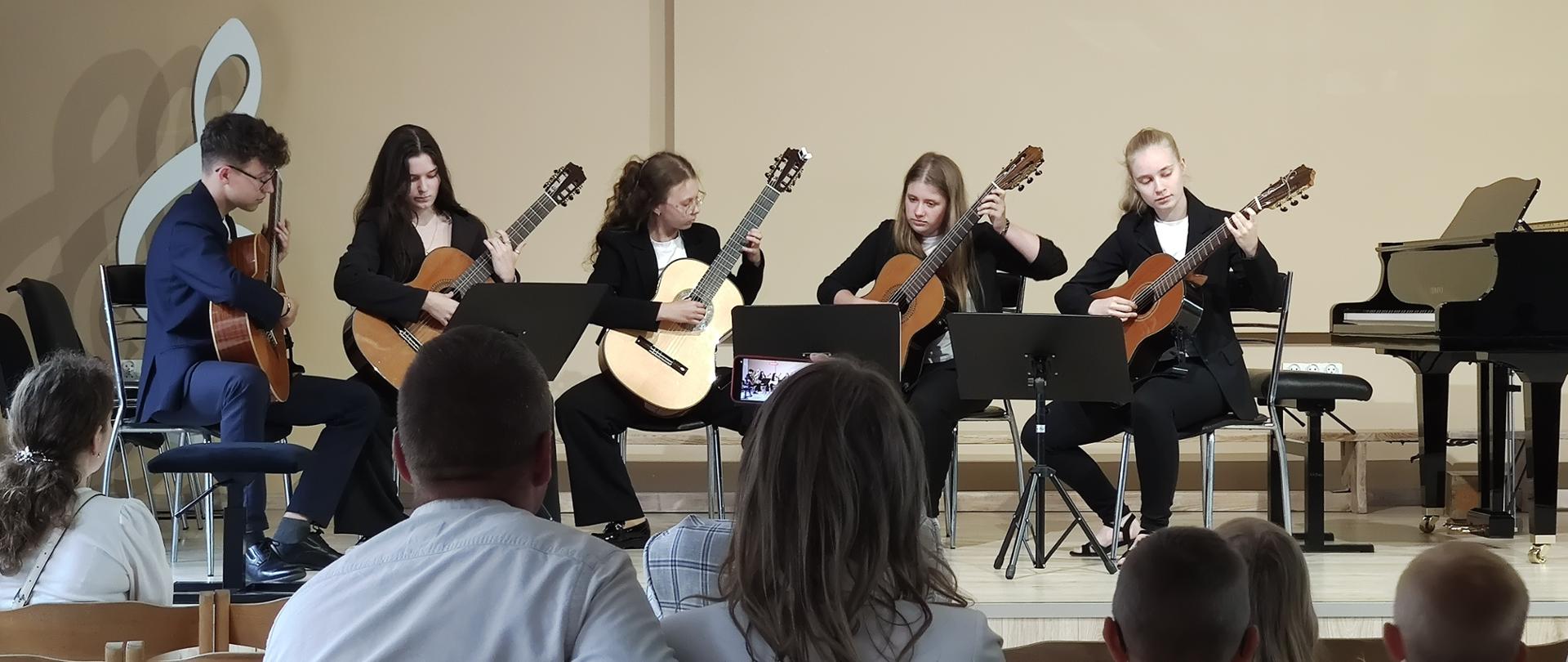 zespół gitarowy grający na scenie