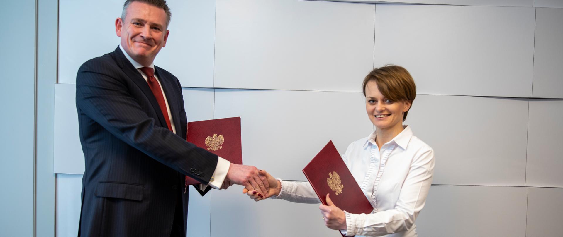 Minister Jadwiga Emilewicz i dyrektor zarządzający ABB w Polsce podpisują umowę
