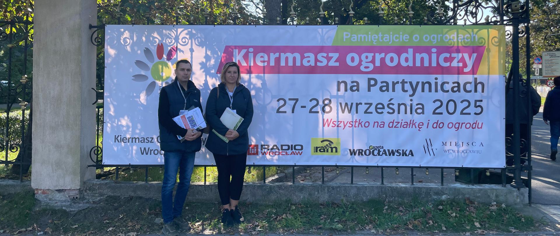 Inspektorzy stojący przy plakacie.