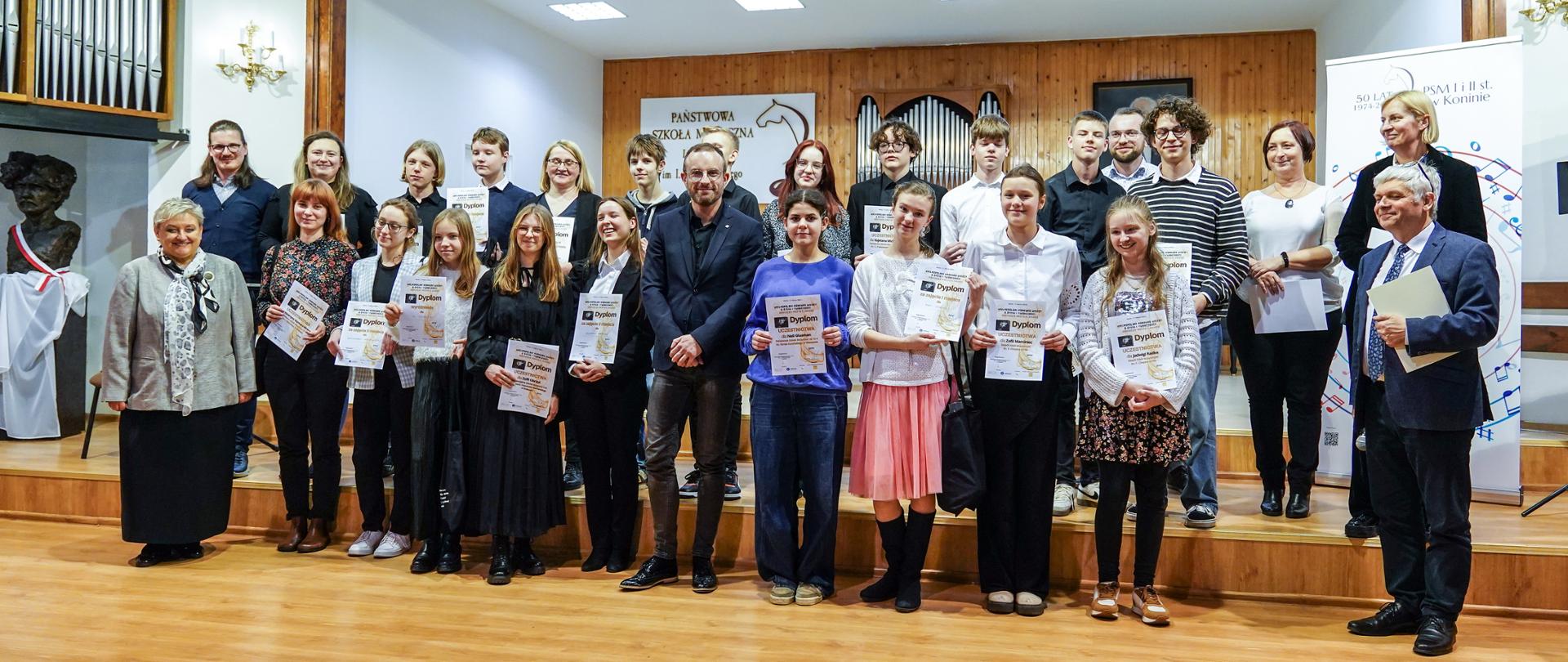 Uczestnicy konkursu wraz z Jury i Kompozytorem stoją na scenie PSM w Koninie