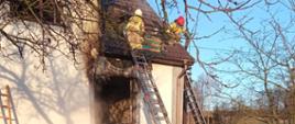 Strażacy gaszą pożar domu w Jasienicy - rozbiórka poszycia dachowego. 