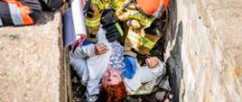 Strażak udzielający poszkodowanej pierwszej pomocy