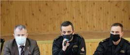 Na zdjęciu widać stół prezydialny i prowadzących spotkanie tj. przemawia komendant powiatowy PSP we Włoszczowie – st. kpt. Andrzej Pacanowski, obok siedzi Wicestarosta – Łukasz Karpiński oraz bryg. Tomasz Szymański z KP PSP Włoszczowa