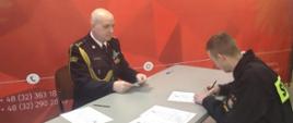 Na zdjęciu Komendant Miejski Państwowej Straży Pożarnej w Sosnowcu oraz strażak składający podpis pod aktem ślubowania