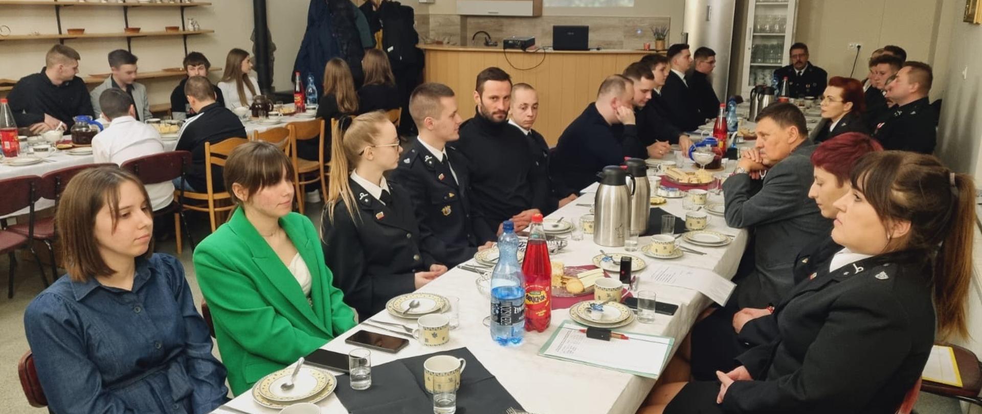 Przy stole siedzą uczestnicy spotkania.