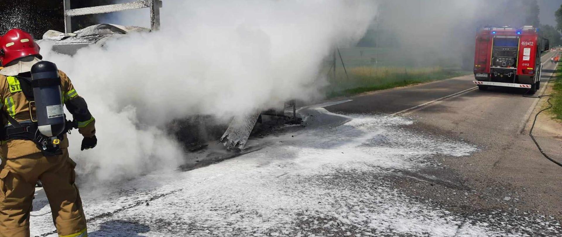 Strażacy gaszą pianą palący się samochód dostawczy