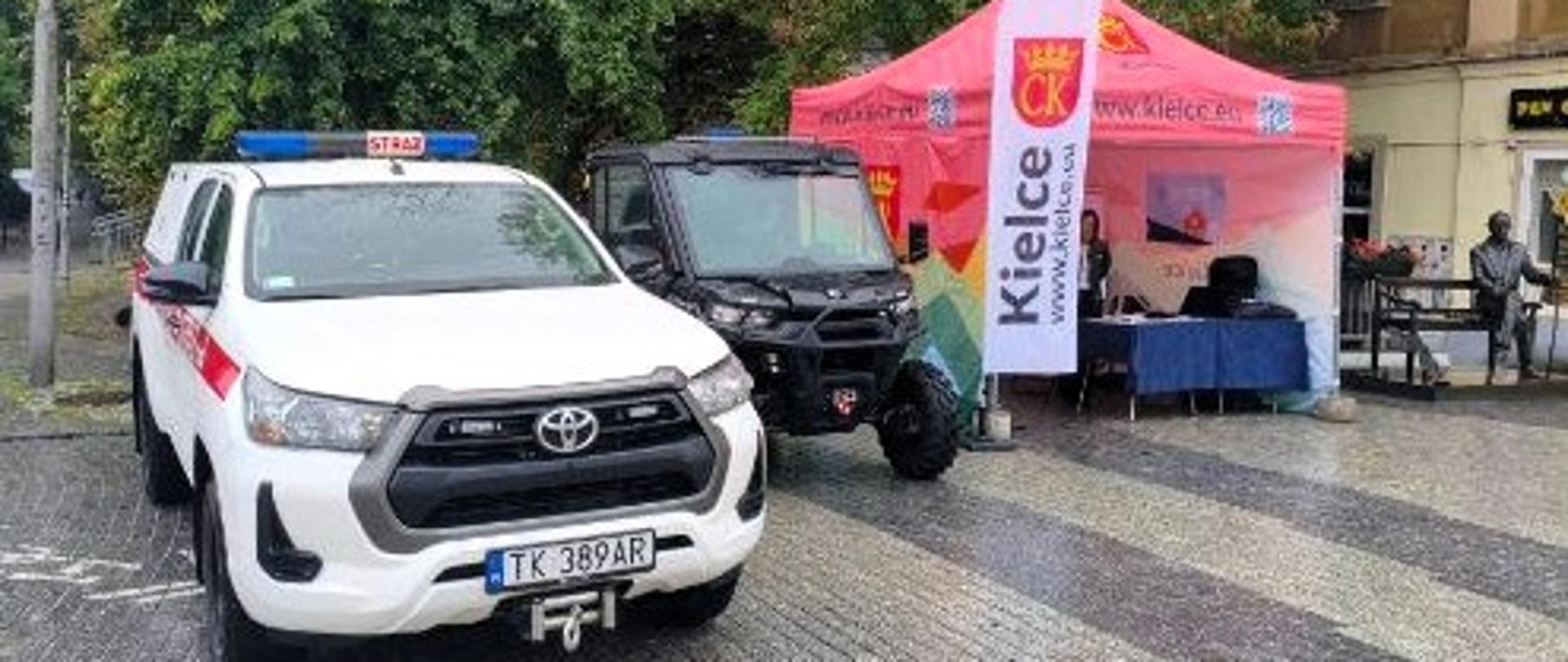 Zdjęcie przedstawia stoisko Urzędu Miasta Kielce oraz stojące przy nim samochody Państwowej Straży Pożarnej.