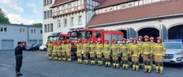 Dowódca JRG oraz strażacy podziału bojowego oddają honory.