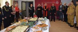 Zdjęcie przedstawia ks. prałata Mieczysława Rusina kapelana strażaków Archidiecezji Przemyskiej i ks. dr Mariana Hofmana kapelana strażaków powiatu przemyskiego oraz komendanta miejskiego PSP wraz z zastępcą, strażakami i pracownikami cywilnymi KM PSP oraz zaproszonymi gośćmi podczas modlitwy wigilijnej