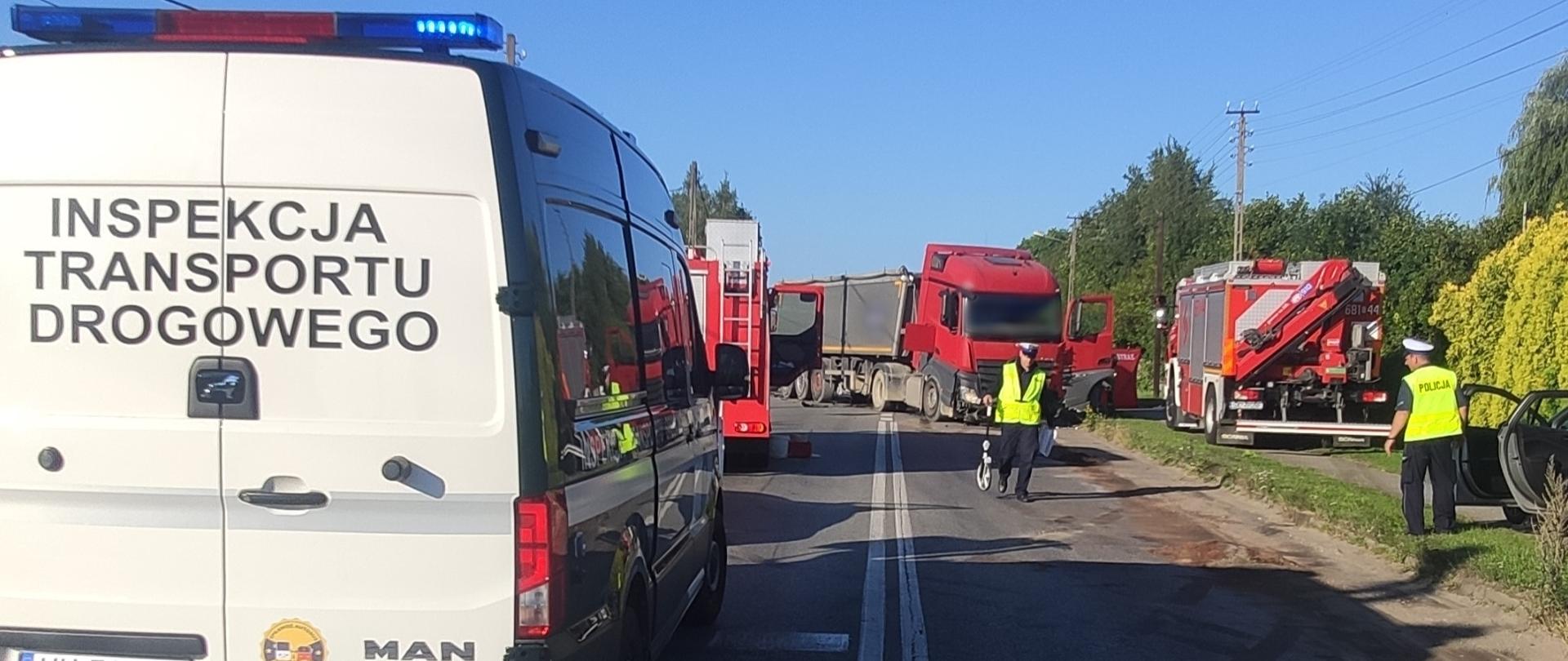 Na pierwszym planie (od lewej strony): tył oznakowanego furgonu śląskiej ITD na miejscu śmiertelnego wypadku drogowego koło Zawiercia. W tle: rozbita ciężarówka i policjanci prowadzący czynności.