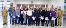 Pamiątkowe zdjęcie grupowe uczestników szkolenia inspektorów ochrony przeciwpożarowej (22 osoby) w towarzystwie p.o. Komendanta Centralnej Szkoły PSP, kobiety oraz dwóch funkcjonariuszy CS PSP