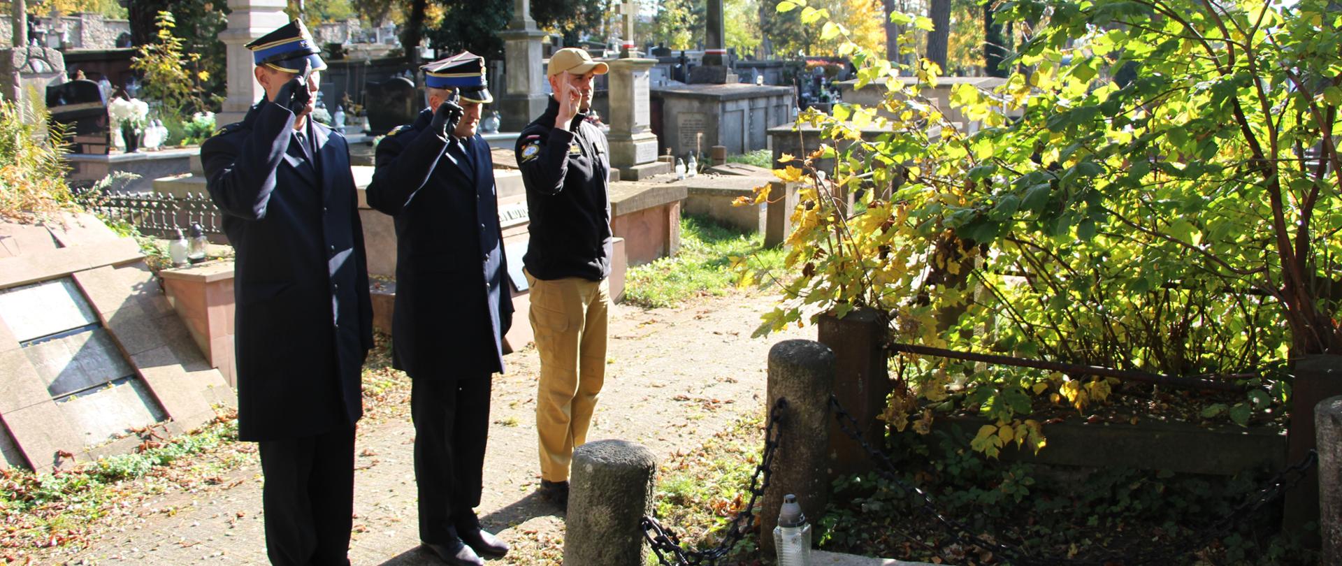 Zdjęcie przedstawia komendantów miejskich Państwowej Straży Pożarnej w Kielcach, którzy wraz z zastępcą dowódcy JRG 1 oddają honor przy grobie zasłużonego dla ochrony przeciwpożarowej.