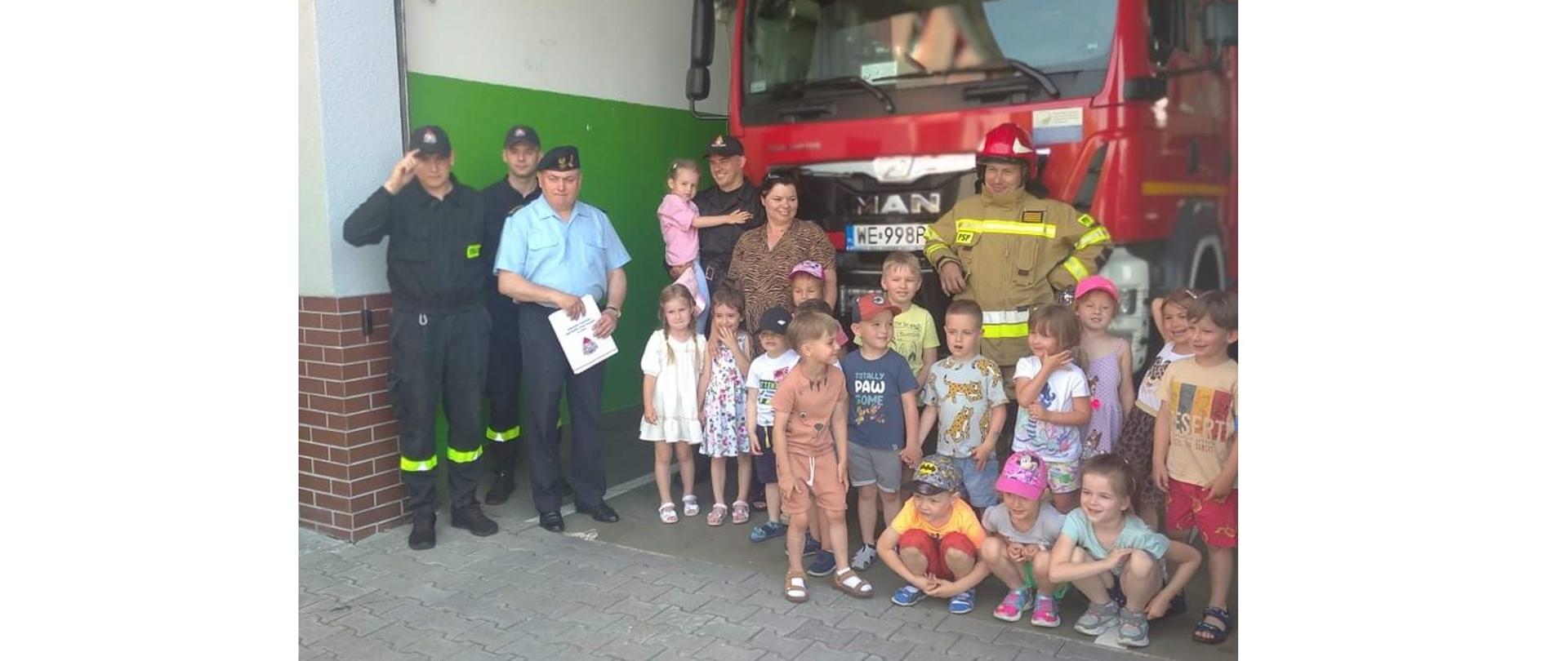 Zdjęcie grupowe na tle wozów bojowych PSP