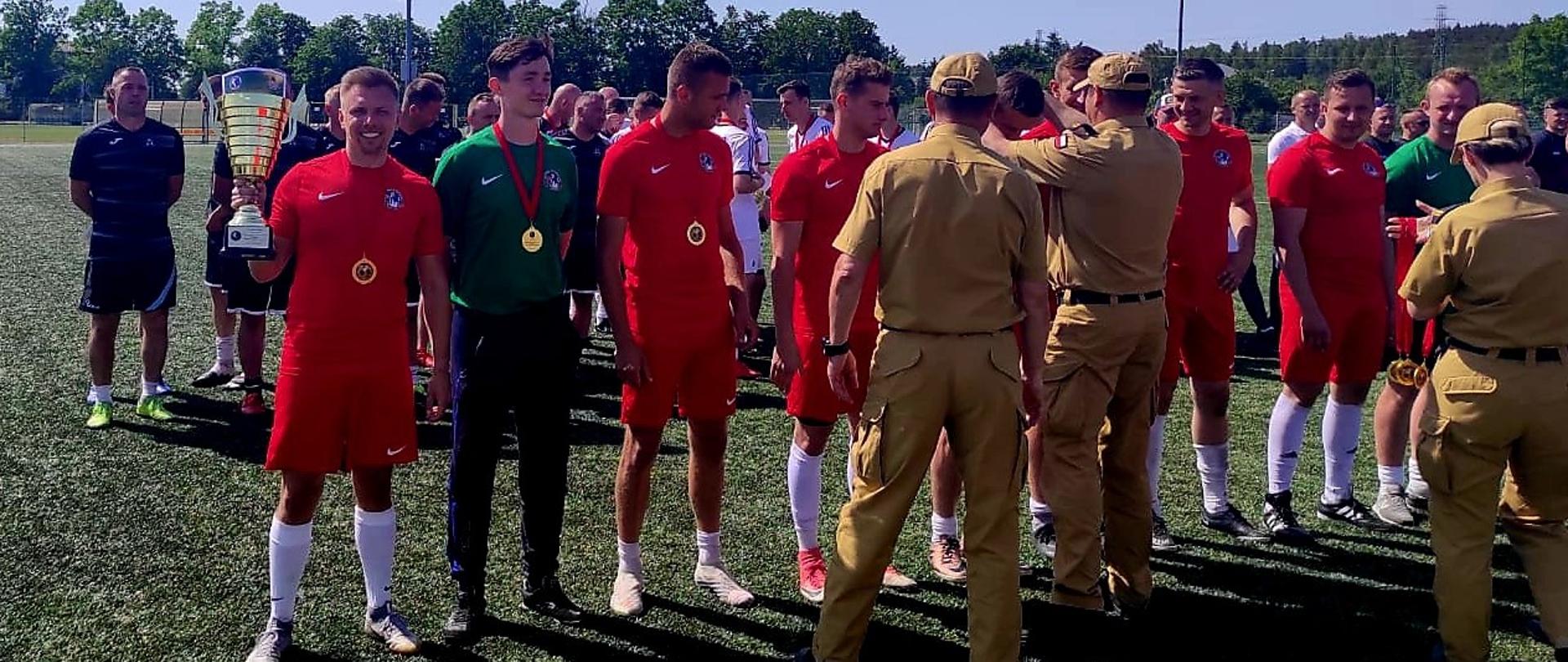 Zdjęcie przedstawia piłkarzy z pucharem