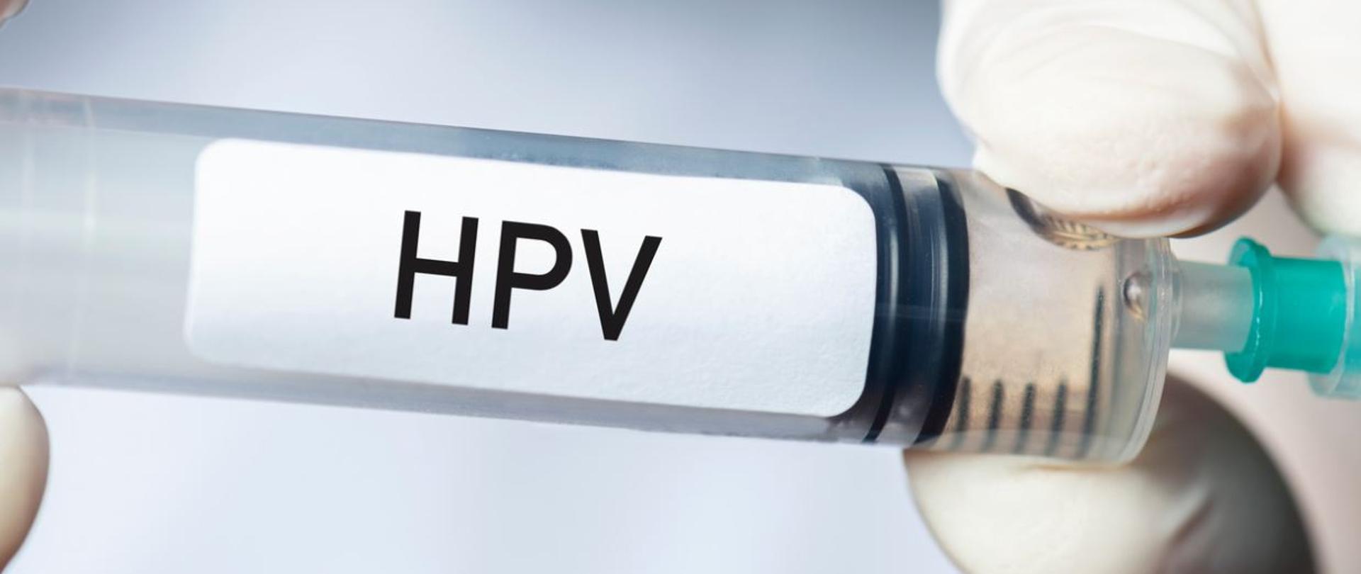 Trzymana w dłoniach strzykawka, na której napisane jest: HPV.