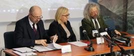 Zdjęcie z uroczystości podpisania umowy o dofinansowanie dla TPN. Od lewej siedzą: zastępca prezesa NFOŚiGW Robert Gajda, ministra klimatu i środowiska Paulina Hennig-Kloska i Dyrektor Tatrzańskiego Parku Narodowego Szymon Ziobrowski