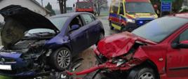Zdjęcie przedstawia dwa uszkodzone samochody
