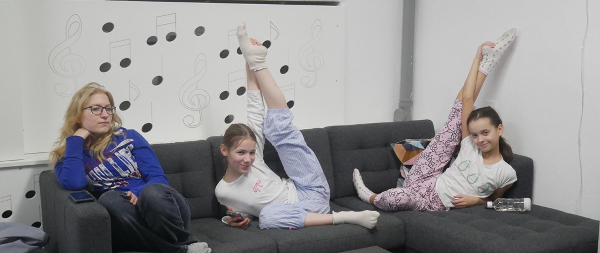 W oczekiwaniu na Kahoota: Wychowanki siedzą na kanapie. Dwie z nich wykonują pozę baletową.