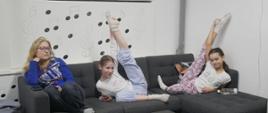 W oczekiwaniu na Kahoota: Wychowanki siedzą na kanapie. Dwie z nich wykonują pozę baletową.
