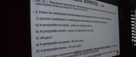 Narada operacyjno-szkoleniowa. W świetlicy komendy odbywa się narada z udziałem pracowników urzędów, komendantów gminnych i przedstawicieli OSP. Na ekranie wyświetlony jest slajd "Świadczenie ratownicze". 