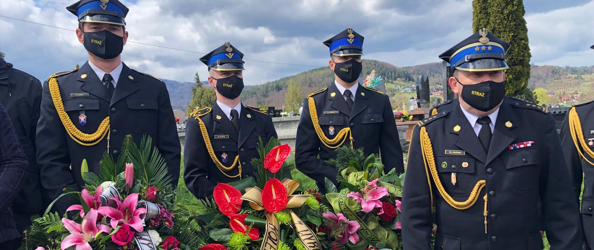 Delegacje z wieńcami stoją na cmentarzu.