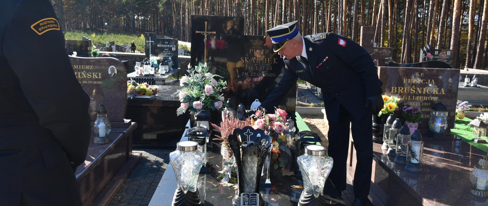 Komendant Powiatowy PSP Skarżysko-Kamienna stawia znicz na grobowcu zmarłego strażaka. Byłego funkcjonariusza KP PSP Skarżysko-Kamienna.