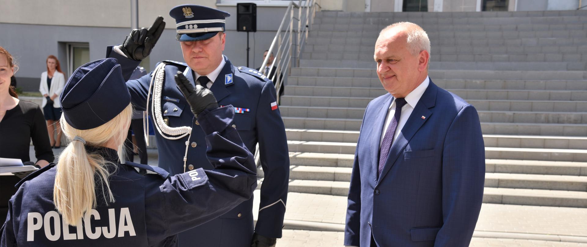Wojewoda z komendantem wojewódzkim policji wręcza odznaczenie policjantce (stoi tyłem do obiektywu). 