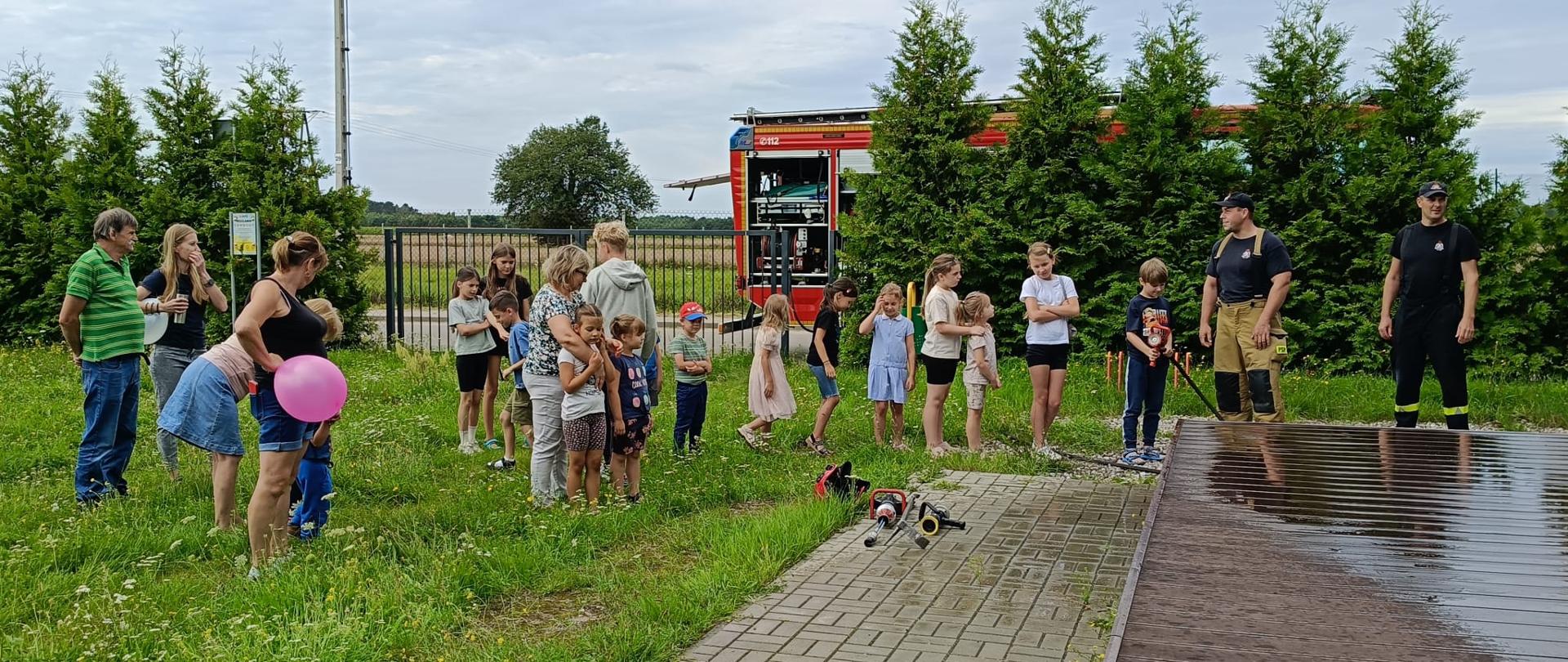 Funkcjonariusze z Komendy Powiatowej PSP w Makowie Mazowieckim opowiadają dzieciom i ich opiekunom o pracy strażaka. Zajęcia odbywają się na świeżym powietrzu.