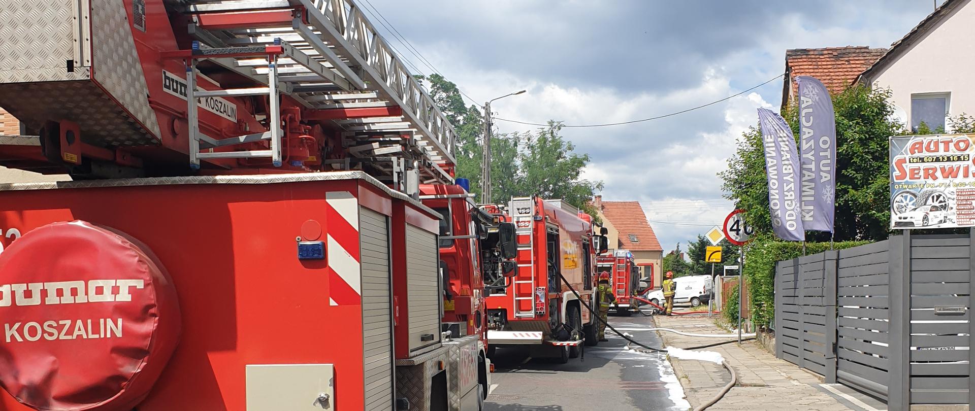 Ustawione na ulicy Słowackiego samochody straży pożarnej podczas pożaru budynku.