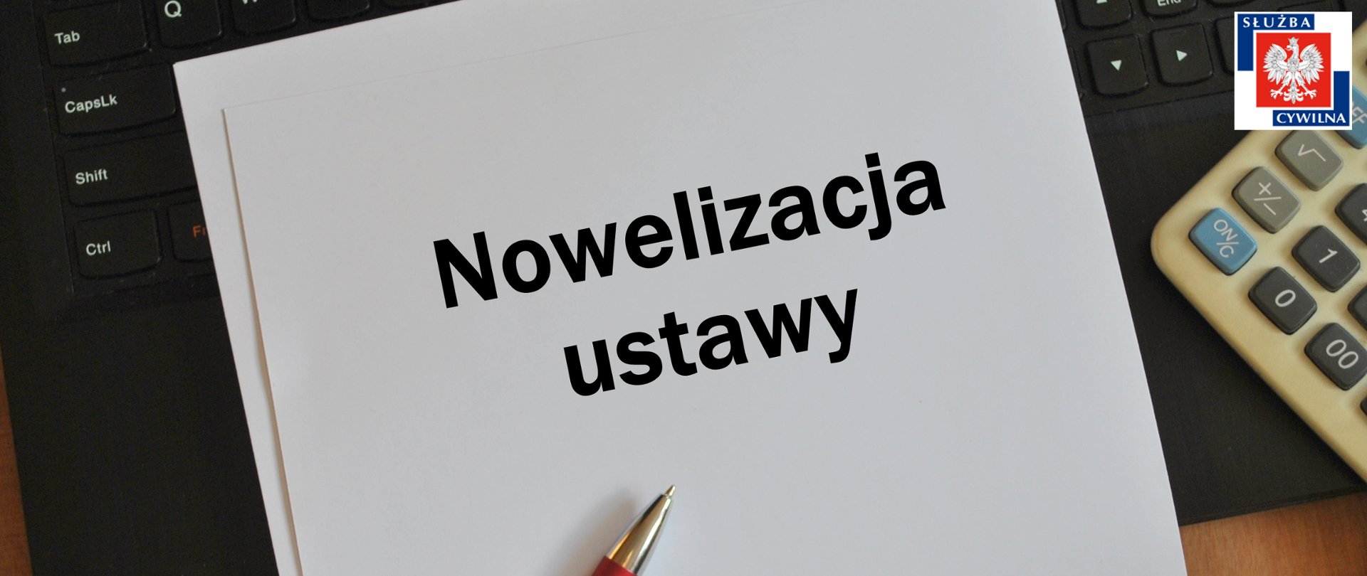 Kartka na której jest napisane "Nowelizacja ustawy". długopis, kalkulator, klawiatura komputera, logo służby cywilnej
