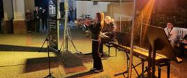 Zdjęcie przedstawia Dominikę Kurzawę grającą na trąbce oraz Martę Ożelską-Kurzawę akompaniującą na fortepianie.