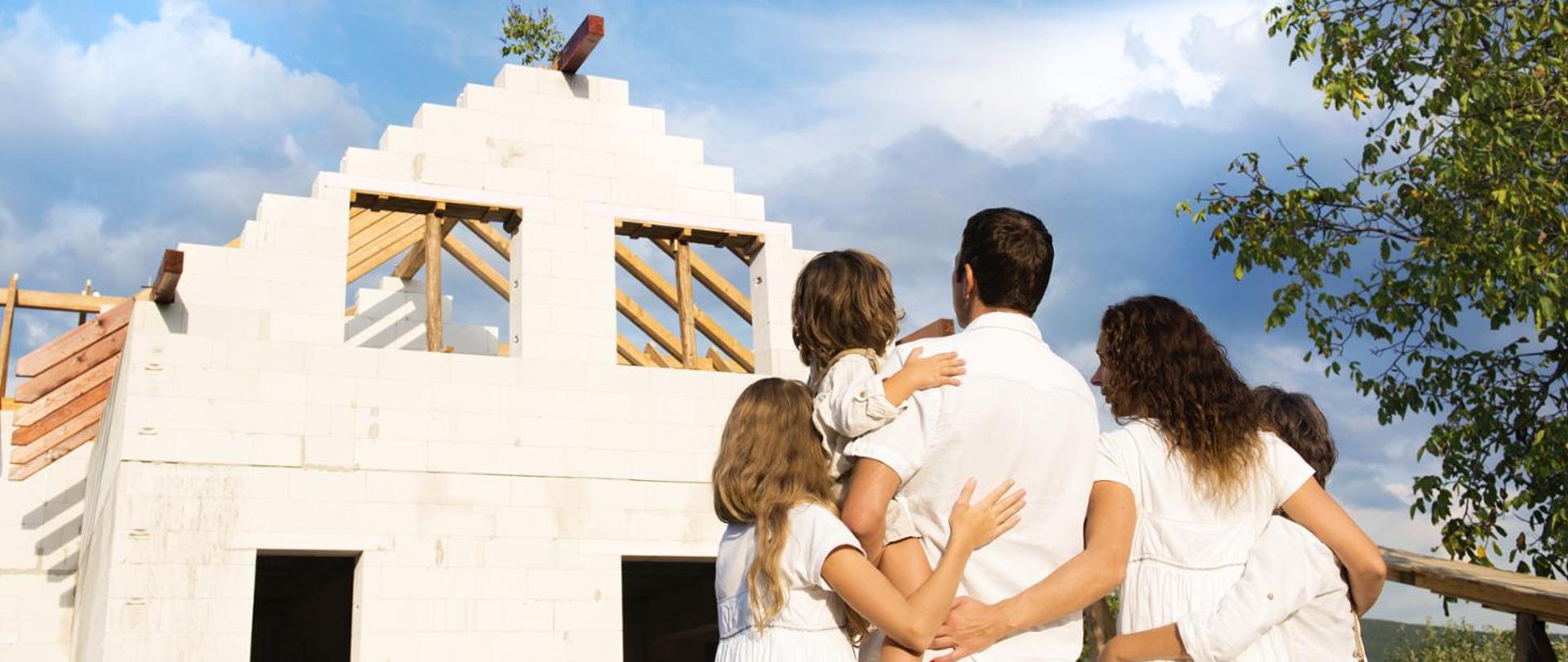 A family looking at an unfinished house