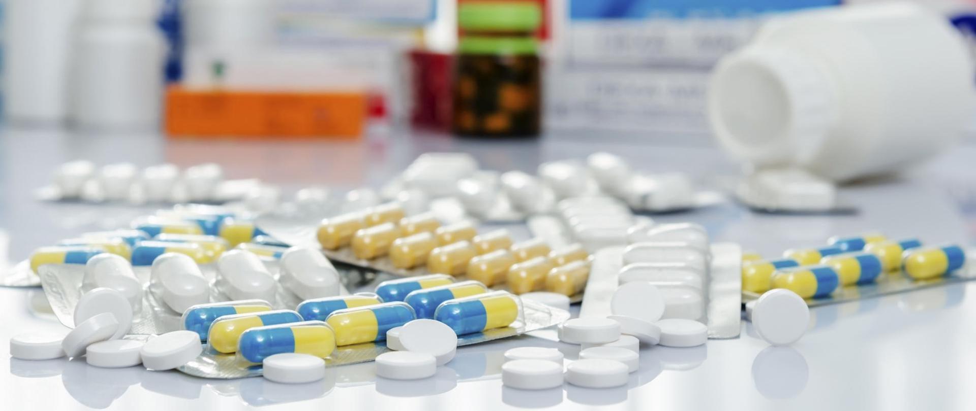 Na zdjęciu widoczne są wszelkiego rodzaju tabletki oraz ich opakowania.