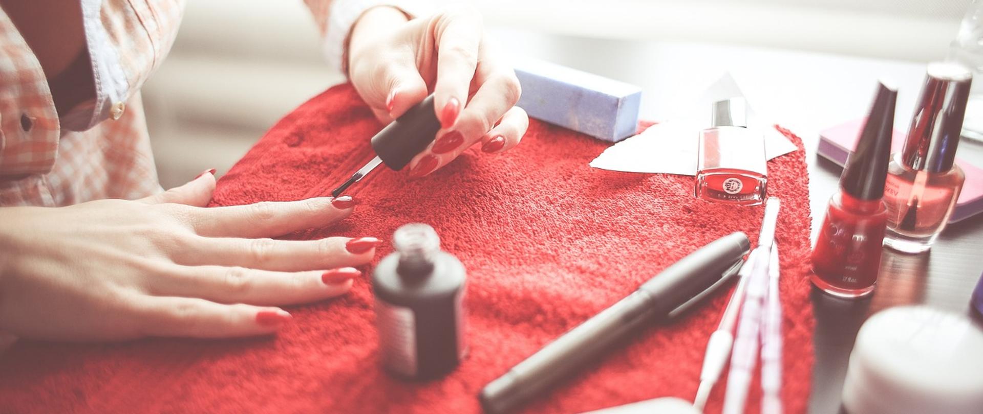 Zdjęcie przedstawiające kobietę malującą paznokcie u rąk