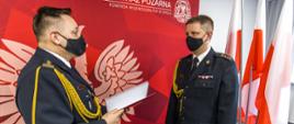 Na zdjęciu widoczny st. bryg. Krzysztof Kędryk Opolski Komendant Wojewódzki PSP w Opolu wręczający decyzję o powołaniu na stanowisko Zastępcy Komendanta Powiatowego PSP w Kluczborku st. kpt. Łukaszowi Olejnikowi.
W tle widoczna czerwona ścianka PSP z białym napisem Komenda Wojewódzka PSP w Opolu i logiem PSP oraz herbem. W tle po prawej stronie widoczne flagi Polski.