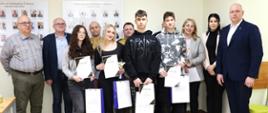 Zdjęcie przedstawia uczestników I Wojewódzkiego Konkursu Wiedzy o Ochronie Ludności i Bezpieczeństwie Powszechnym (eliminacje międzyszkolne) wraz z ich opiekunami oraz przedstawicieli Starostwa Powiatowego w Gołdapi na czele ze Starostą Gołdapskim Panem Krzysztofem Kazanieckim (pierwszy od prawej w pierwszym rzędzie). Na obrazie obecni są również przedstawiciele zespołu sędziowskiego, w tym st. kpt. Bogdan Mielnik oraz st. ogn. Jacek Klimko z Komendy Powiatowej Państwowej Straży Pożarnej w Gołdapi